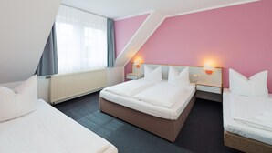 A modern hotel room with a large bed, a smaller bed, and a desk. - Motel Hormersdorf (Schnaittach)
