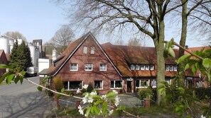 Une maison traditionnelle en briques, dotée d’un toit à forte pente, de nombreuses fenêtres et d’un porche avant bien visible.