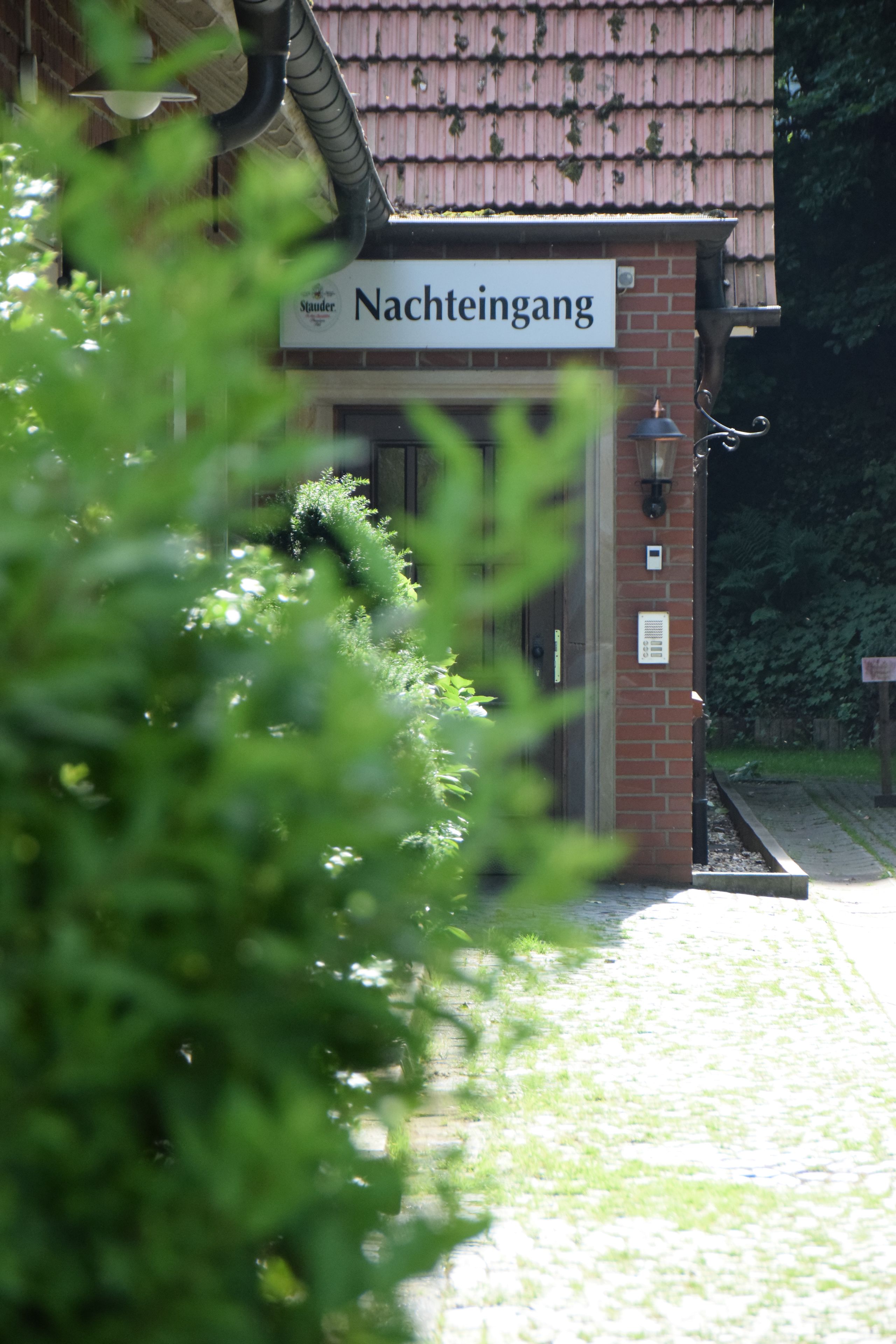 A building with a sign reading "Nachteingang" and a brick facade.