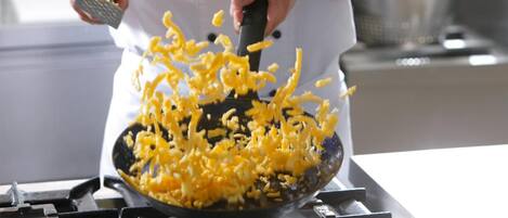 A person grating cheese into a pan.