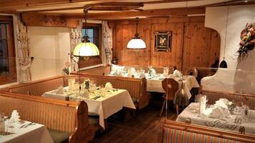 A restaurant with wooden paneling, striped booths, and tables set for dining.