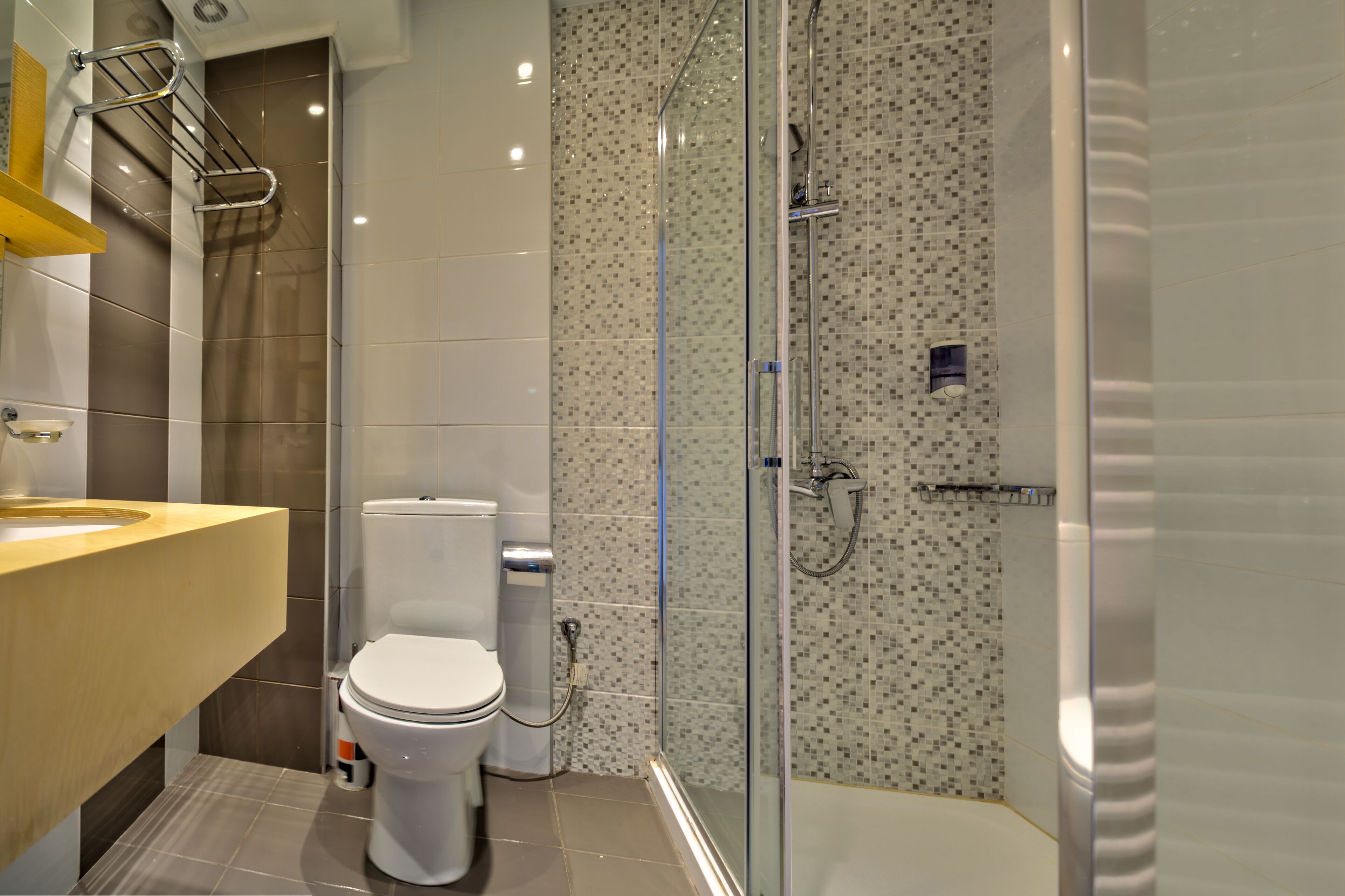 Un baño moderno con inodoro, cabina de ducha y lavamanos.