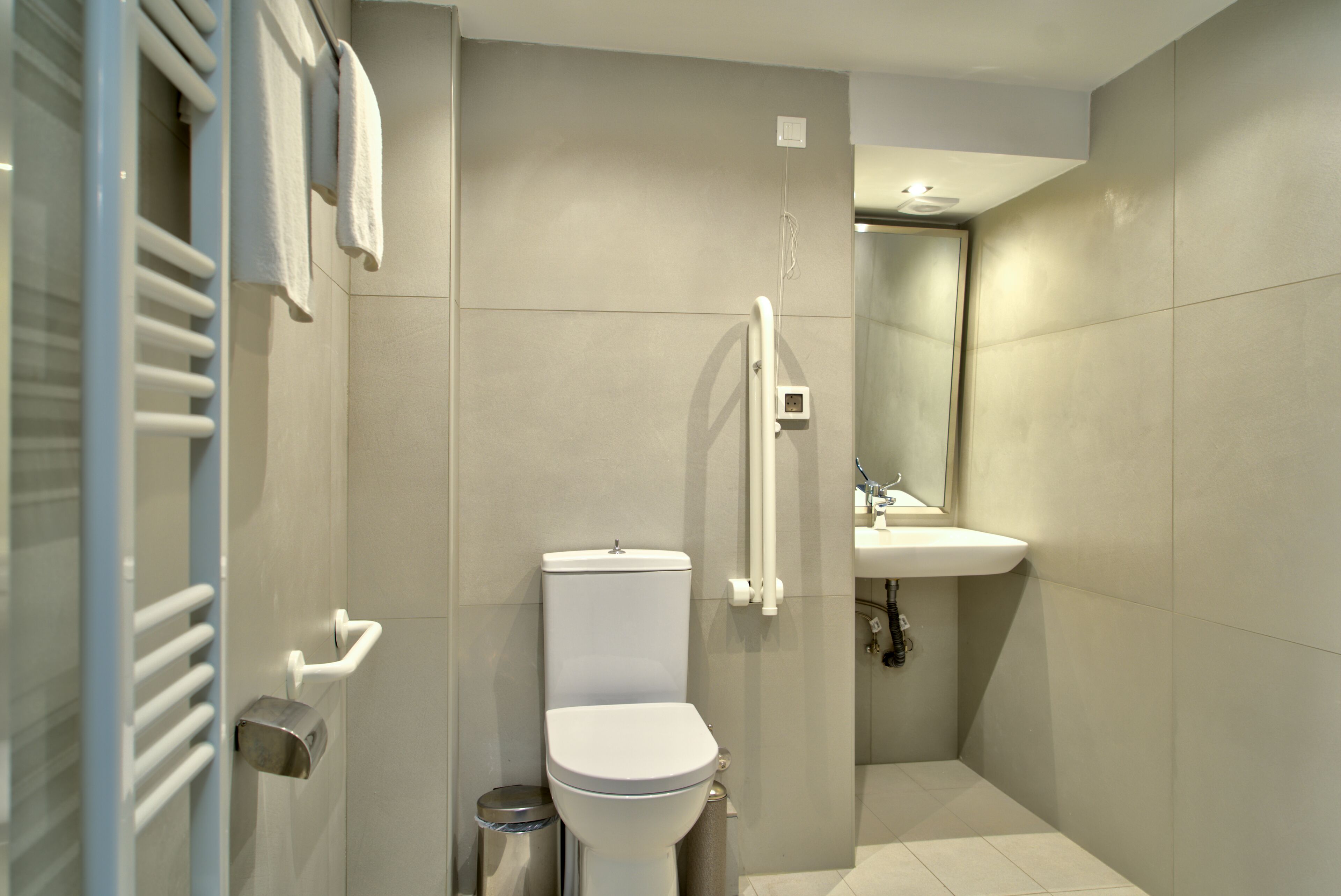Un baño moderno con inodoro, lavamanos y ducha.