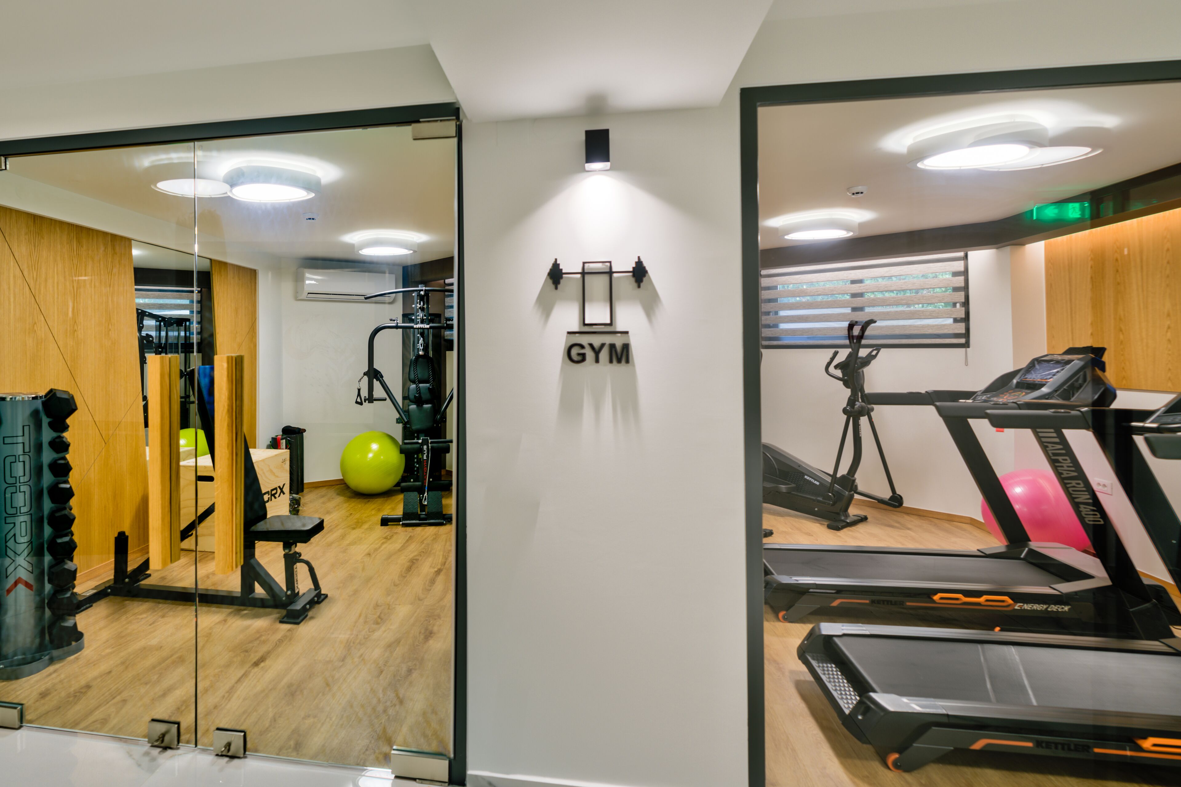 Uma academia com esteiras, bolas de exercício e aparelhos de musculação.