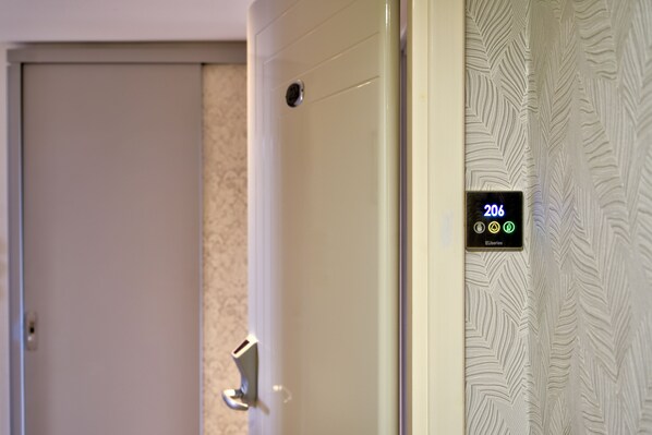 Puerta de una habitación de hotel con una pantalla digital que muestra el número de habitación 206 y un lector de tarjetas.