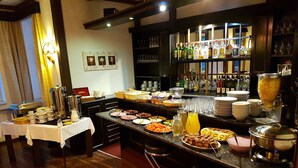A breakfast buffet with various food items, a coffee station, and a bar area with bottles and glasses. - Hotel Marie Luisa (Prague)