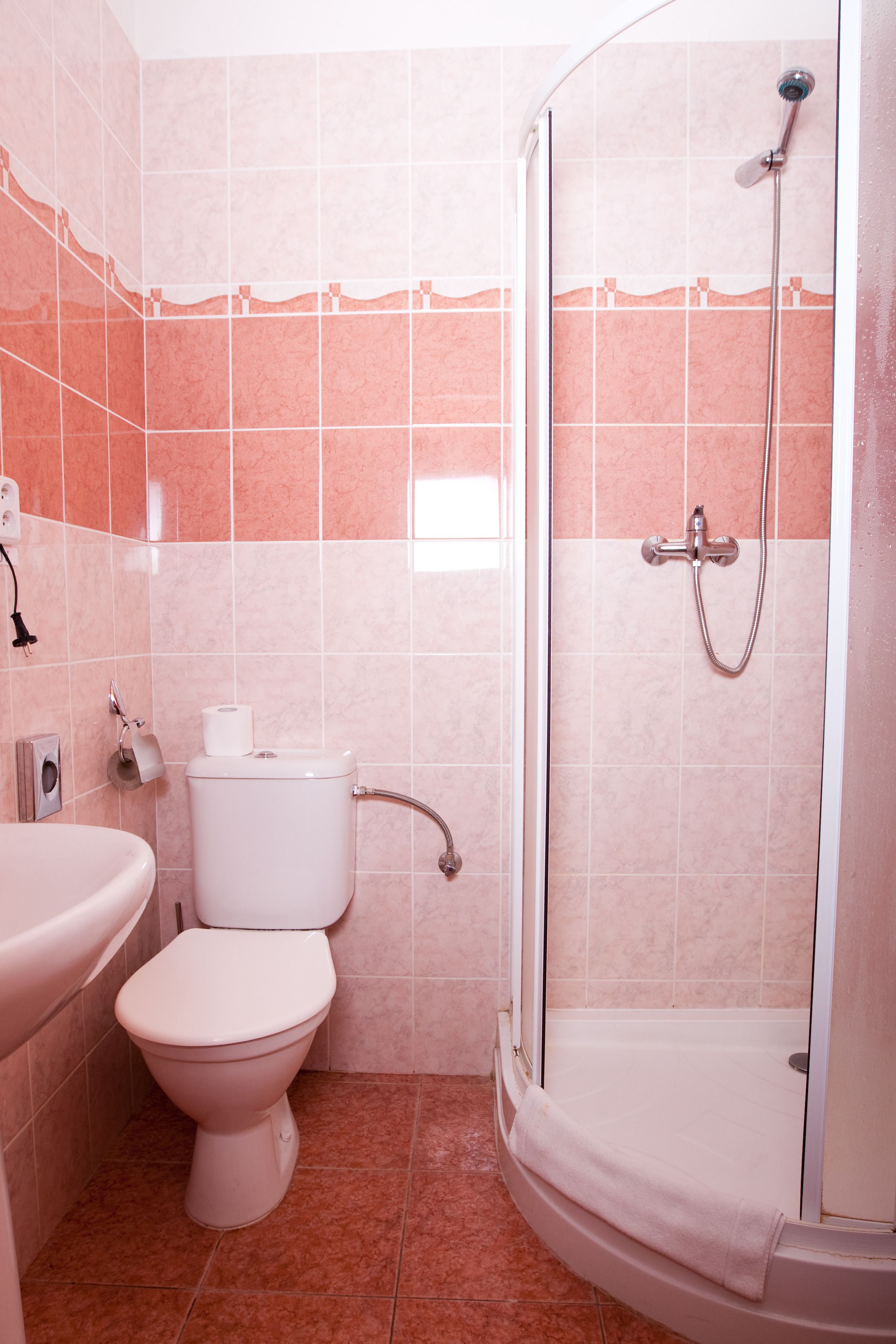A bathroom with a toilet, sink, and shower.