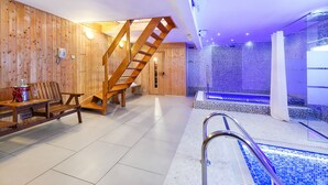 A spa area with wooden walls, a wooden staircase, a seating area, and a blue-lit pool. - Hotel Marie Luisa (Prague)