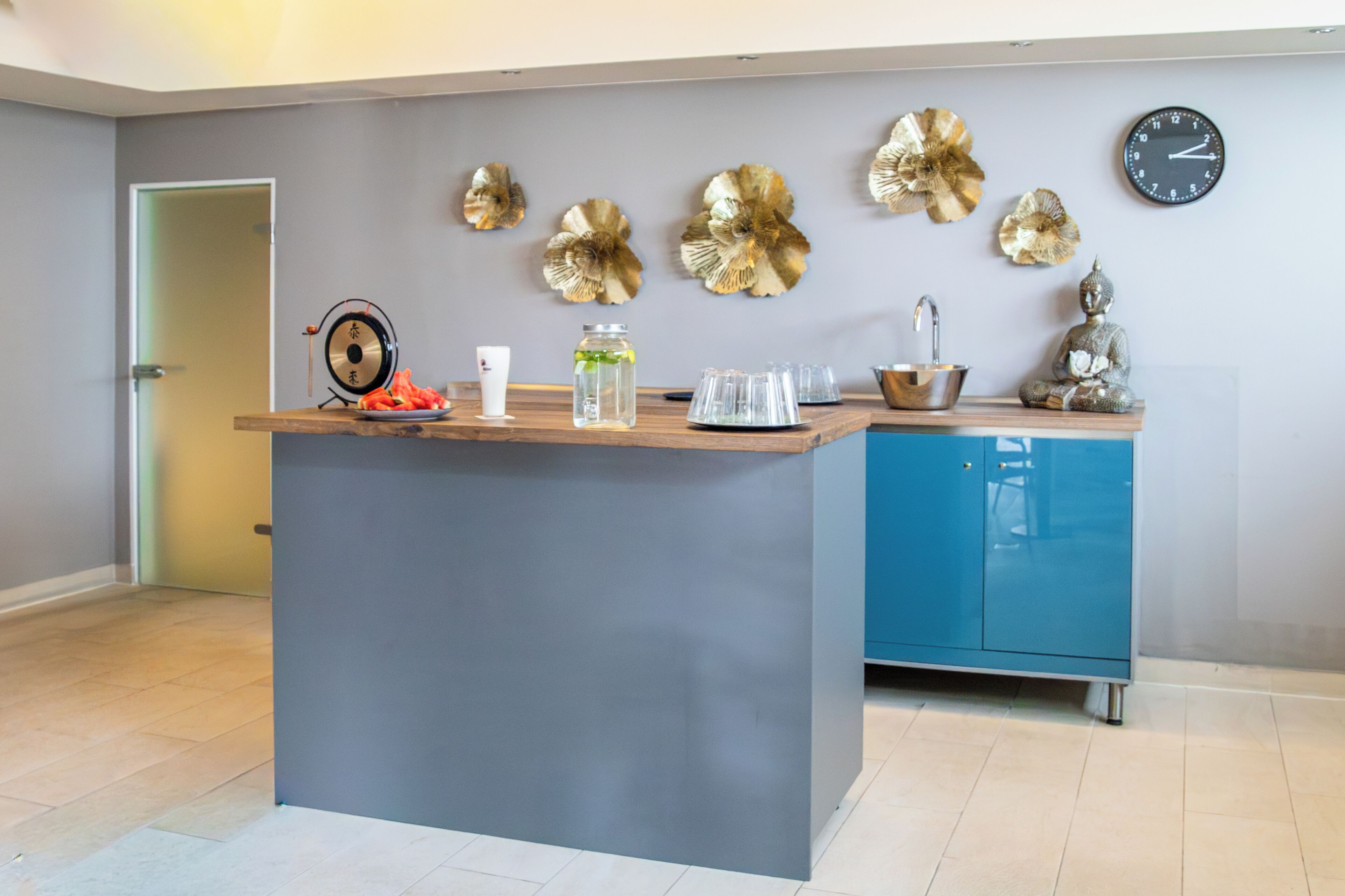 Una cocina moderna con una isla central, un lavamanos y decoración en la pared.
