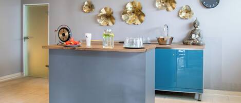 Una cocina moderna con una isla central, un lavamanos y decoración en la pared.