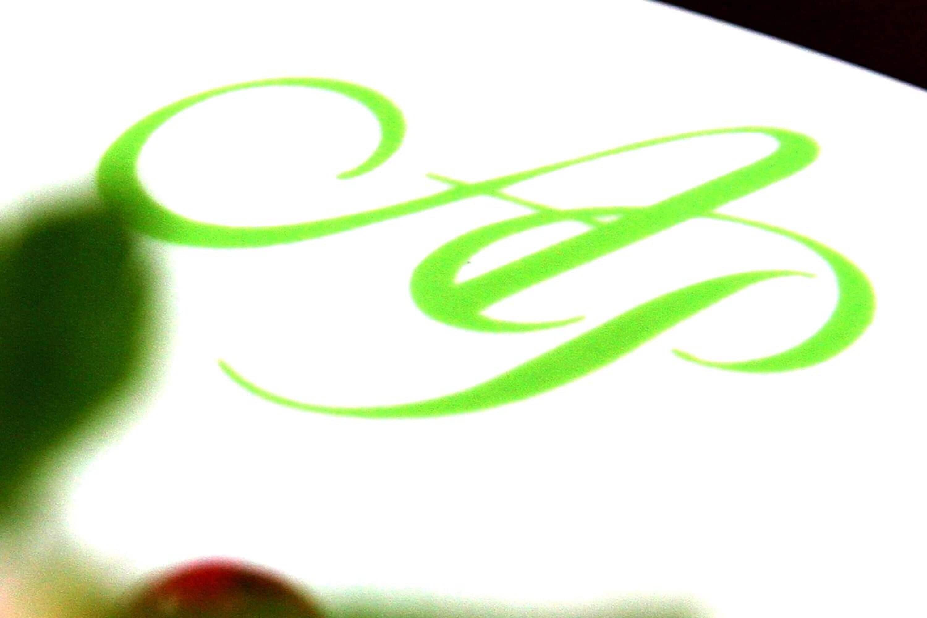 A close-up of a green, cursive script on a white background.