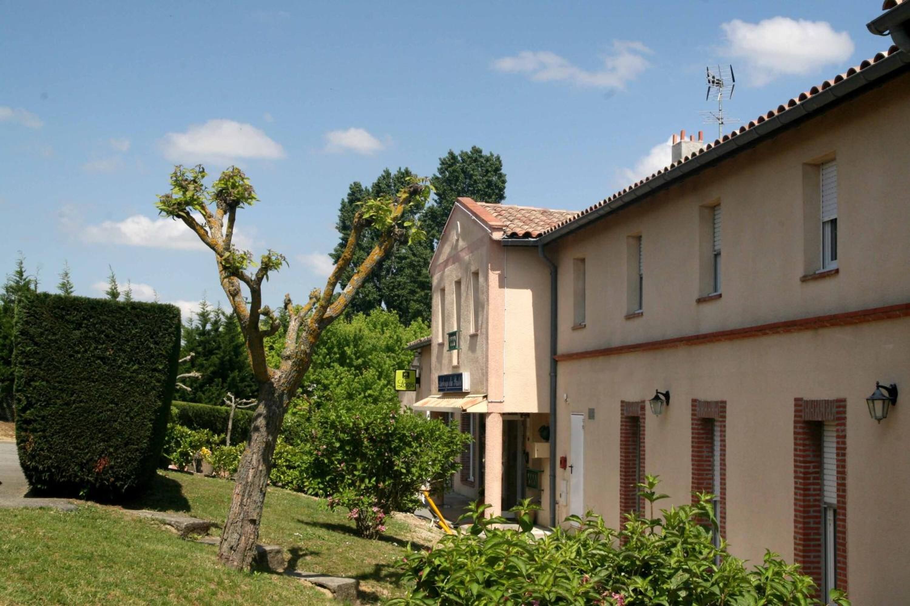 Un bâtiment à deux étages, doté d’une façade beige, de nombreuses fenêtres et d’une porte bien visible.