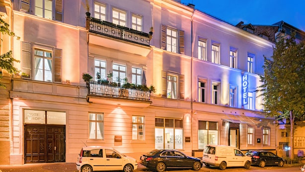 A hotel with a classic facade, multiple windows, and a balcony with plants. - Aurora Hotel (Wiesbaden)