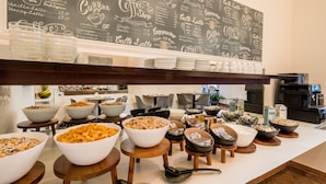 A buffet area with various food bowls and a chalkboard menu above. - Aurora Hotel (Wiesbaden)