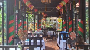 An outdoor dining area with tables and chairs, surrounded by colorful decorations and greenery. - Betel Garden Villas (Da Nang)