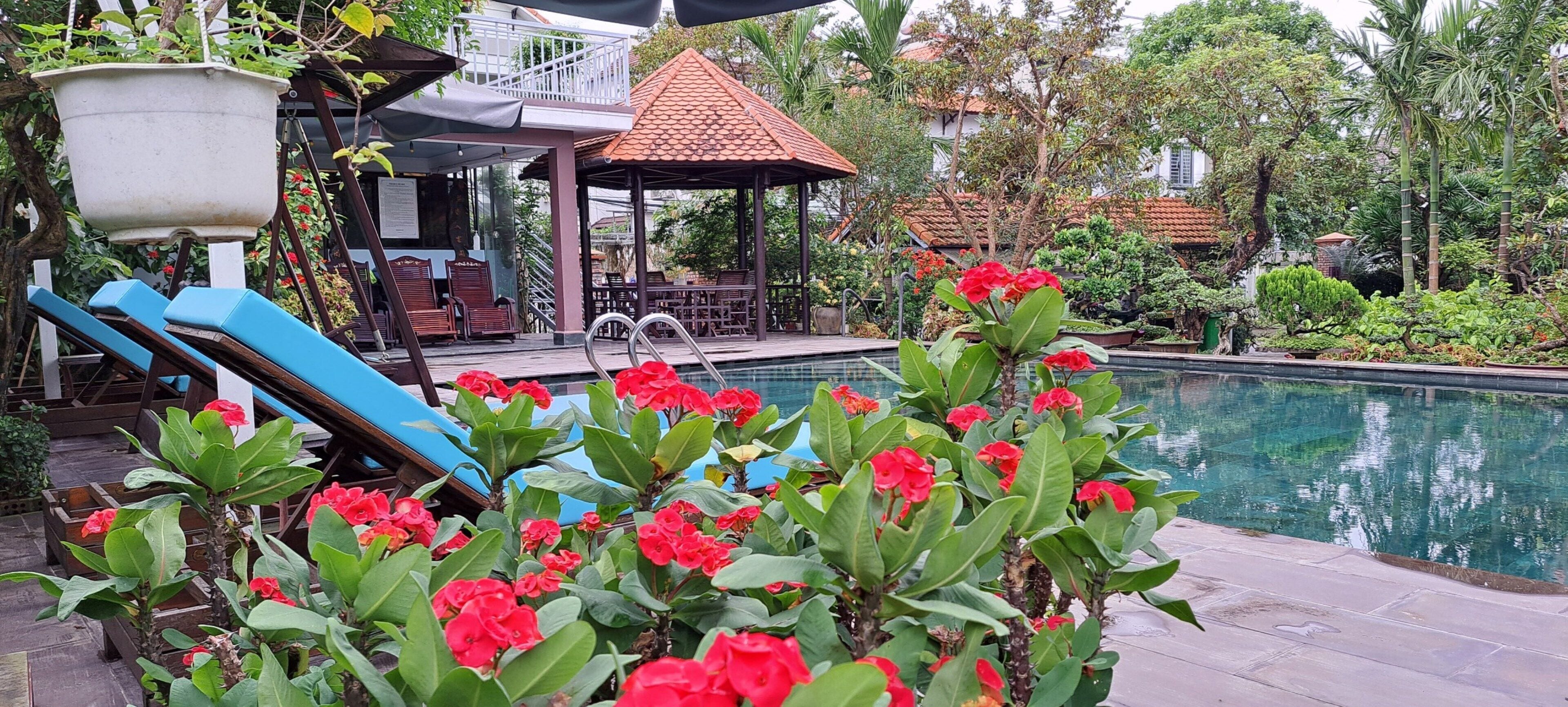 A pool area with a slide, a gazebo, and lush greenery.