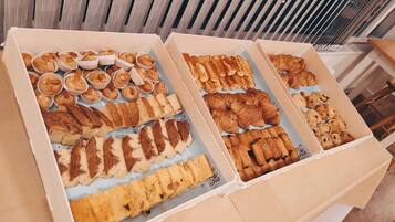 Two open boxes of assorted pastries and baked goods.