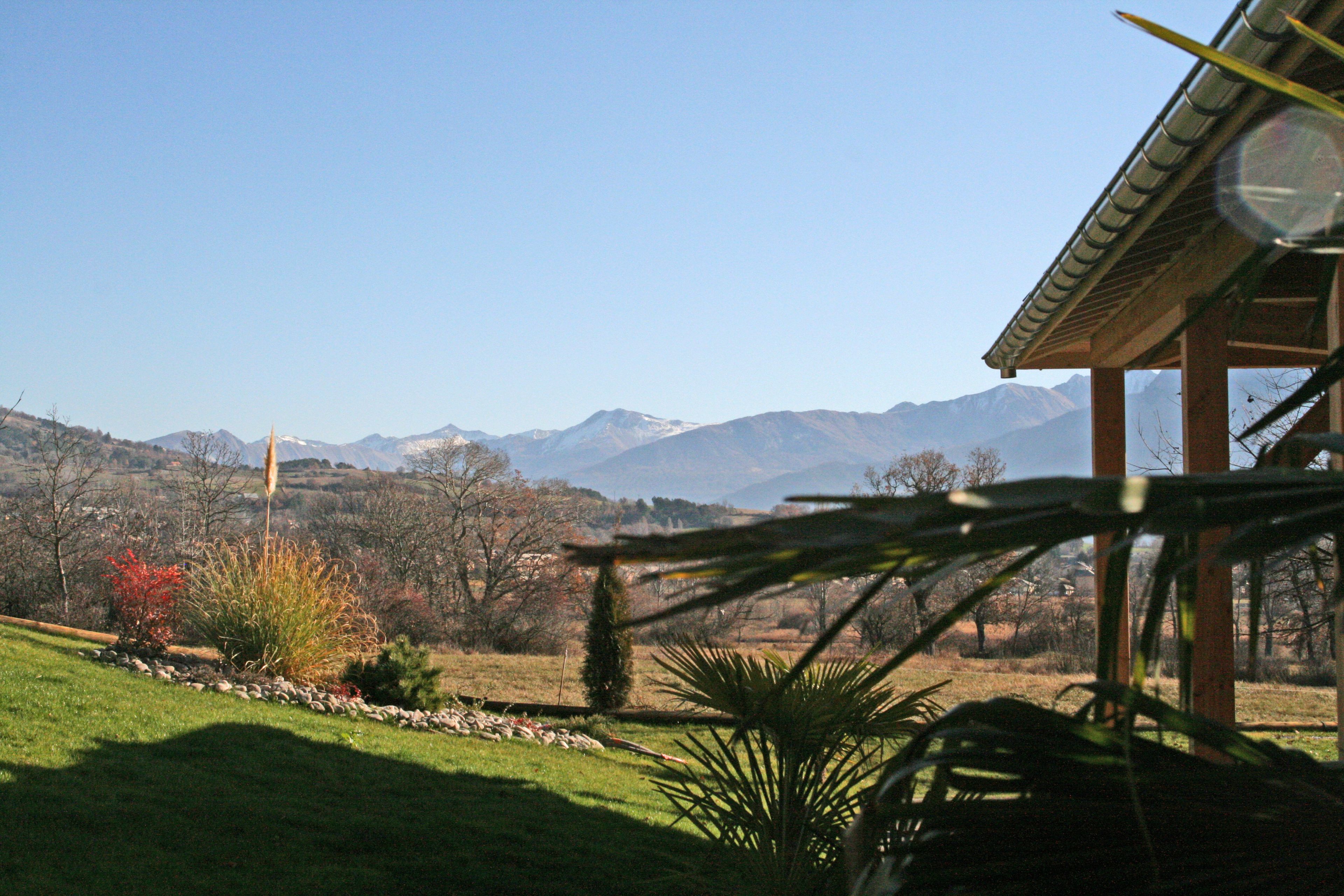 Une vue d’un paysage montagneux avec un bâtiment au premier plan.