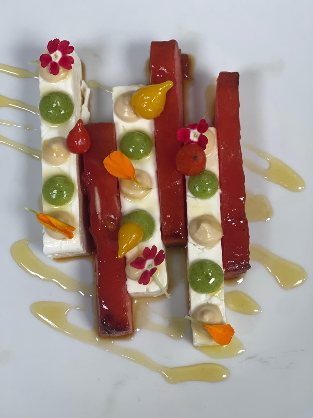 A dessert with various colorful components and a white plate.