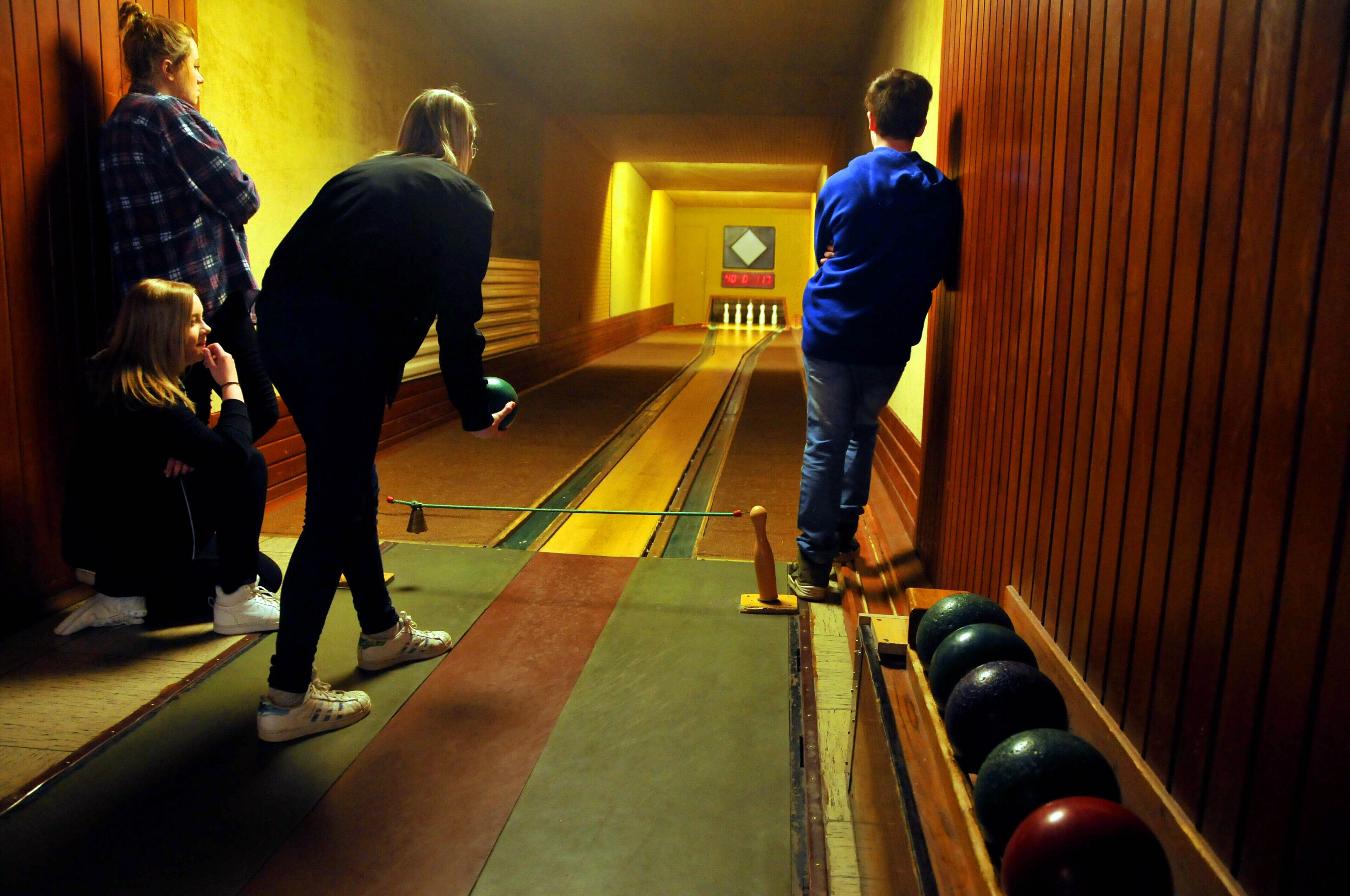 Une salle de bowling avec des pistes, un appareil pour remettre les quilles en place et un système de retour des boules.