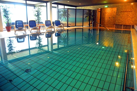 Una piscina techada, sillones reclinables de piscina