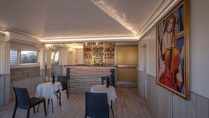 Ravintolassa on baarialue, useita pöytiä ja tuoleja.