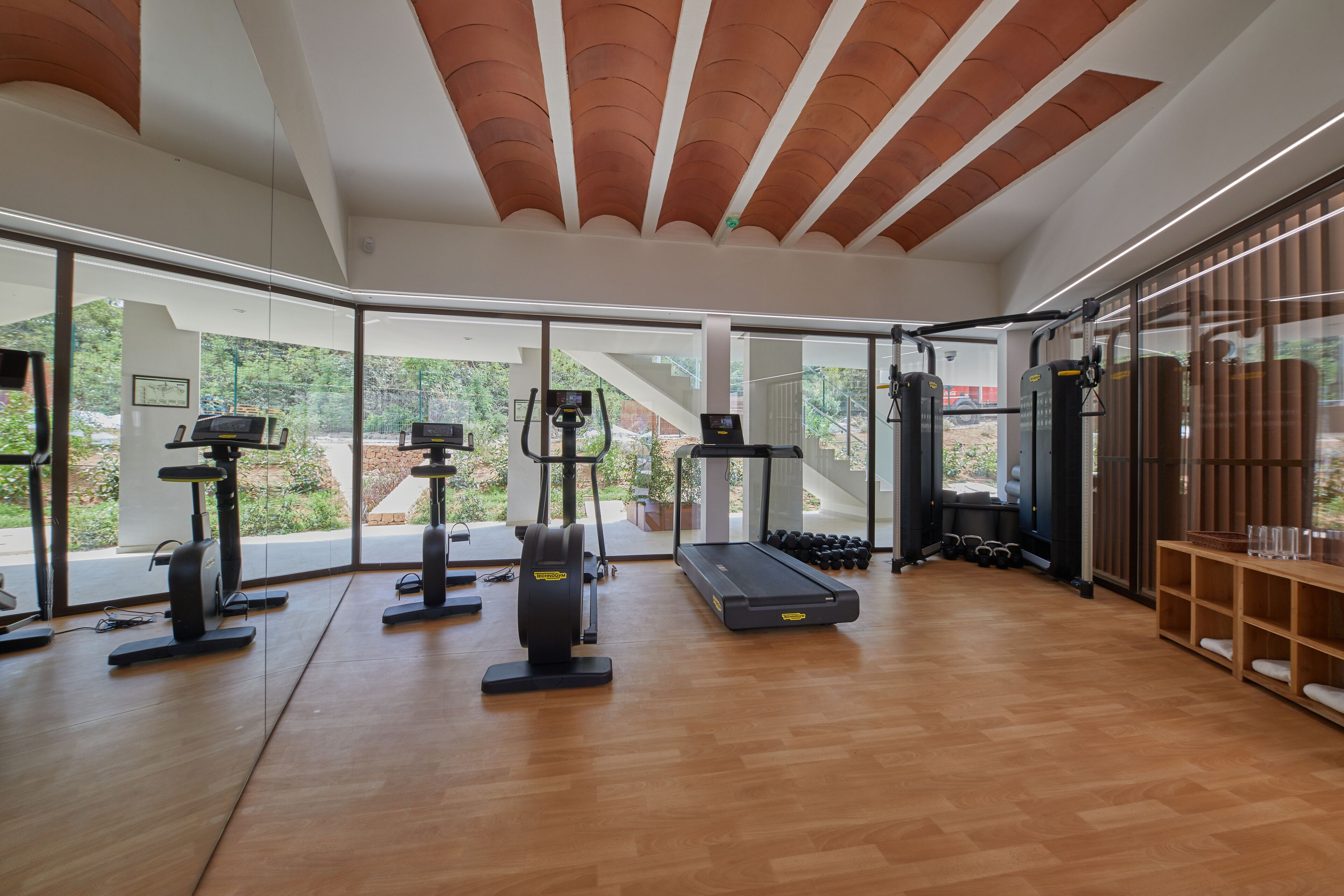 Un gimnasio moderno con equipo cardiovascular, máquinas de pesas y una cinta de correr.