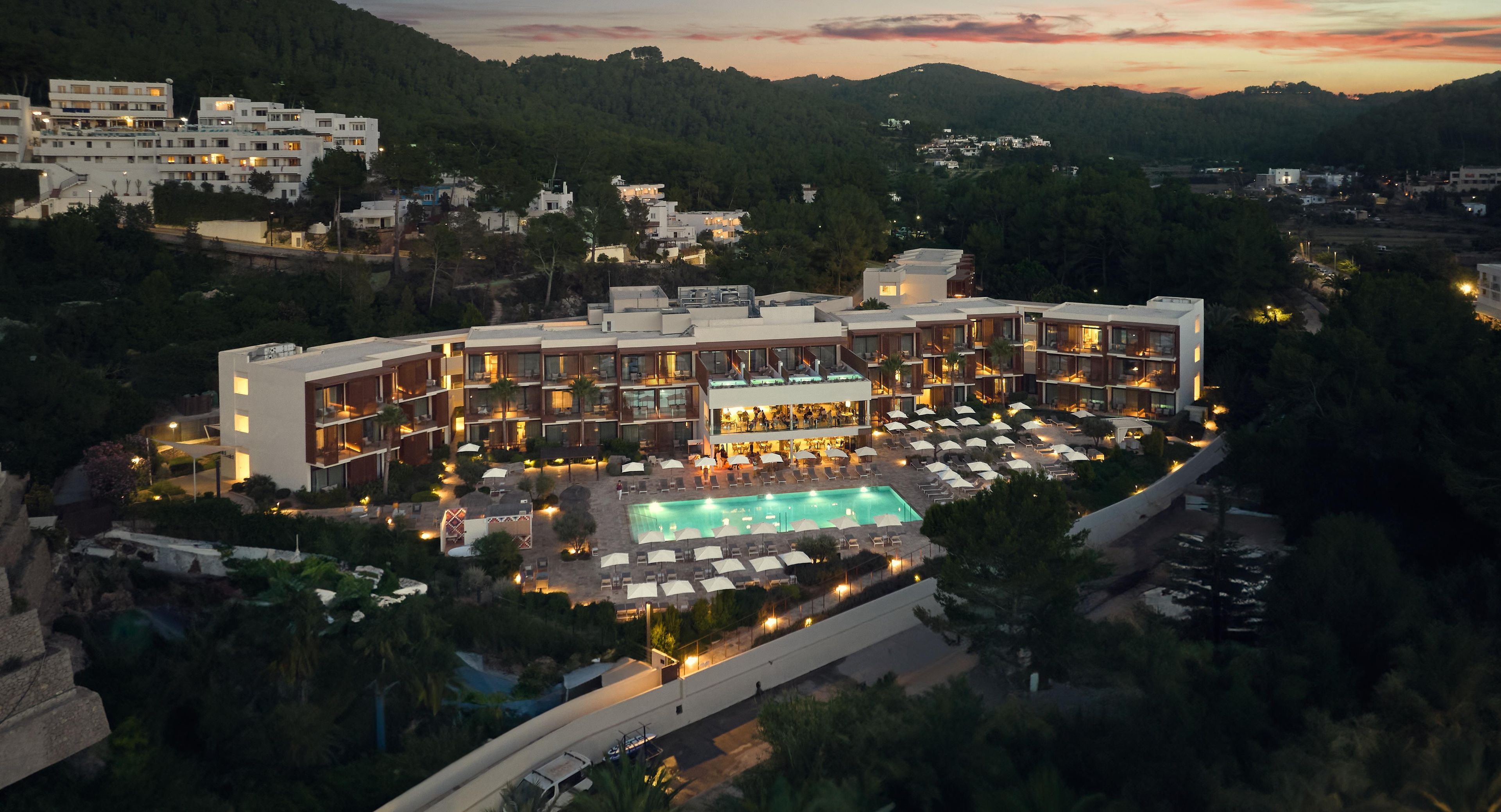 Un hotel de varios pisos con piscina y zona de estar al aire libre.