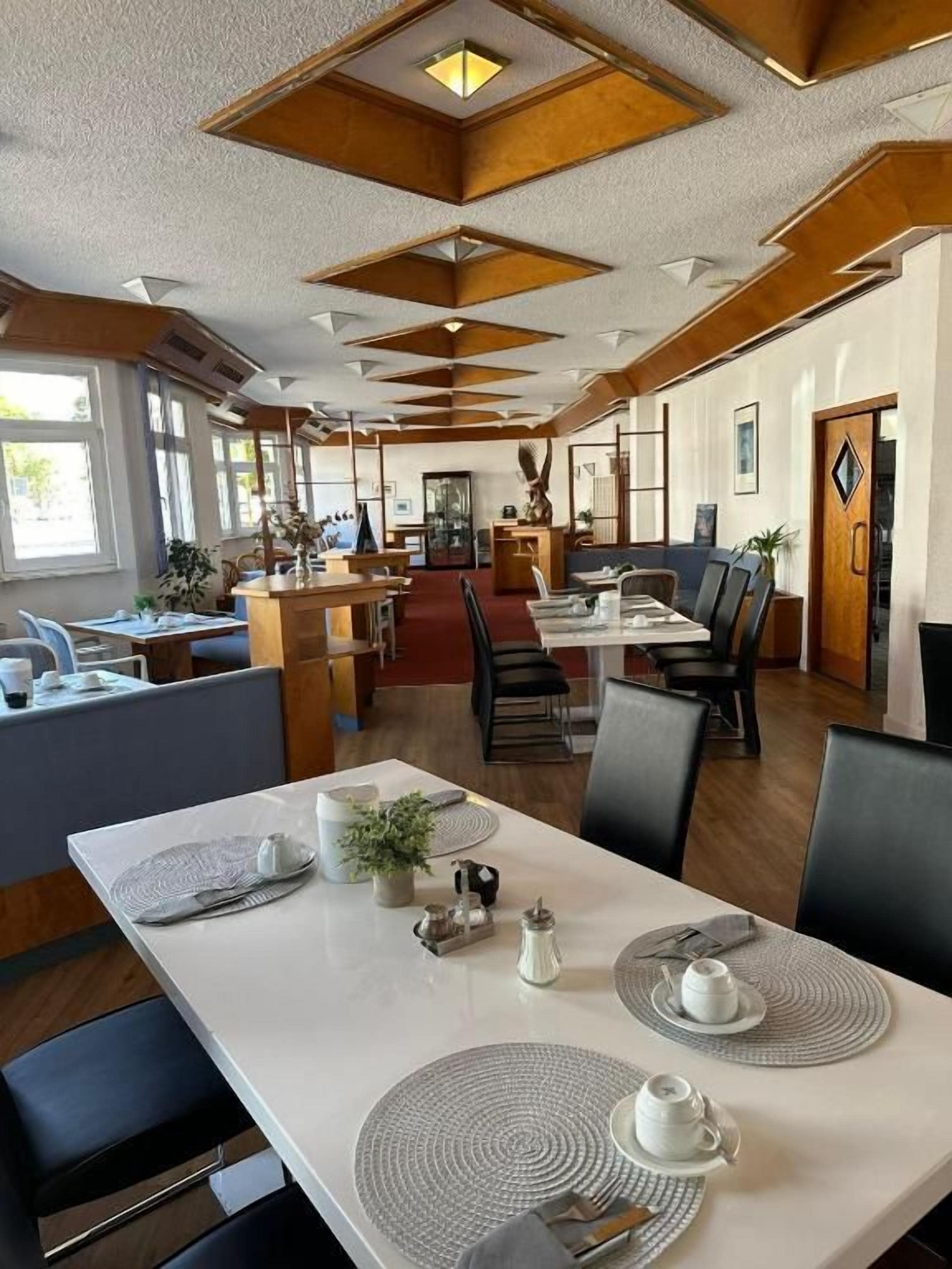 Ein Essbereich mit einem langen Tisch, der für eine Mahlzeit gedeckt ist, umgeben von Stühlen.