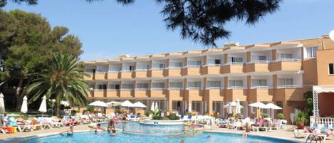 Una piscina al aire libre, sombrillas, sillones reclinables de piscina