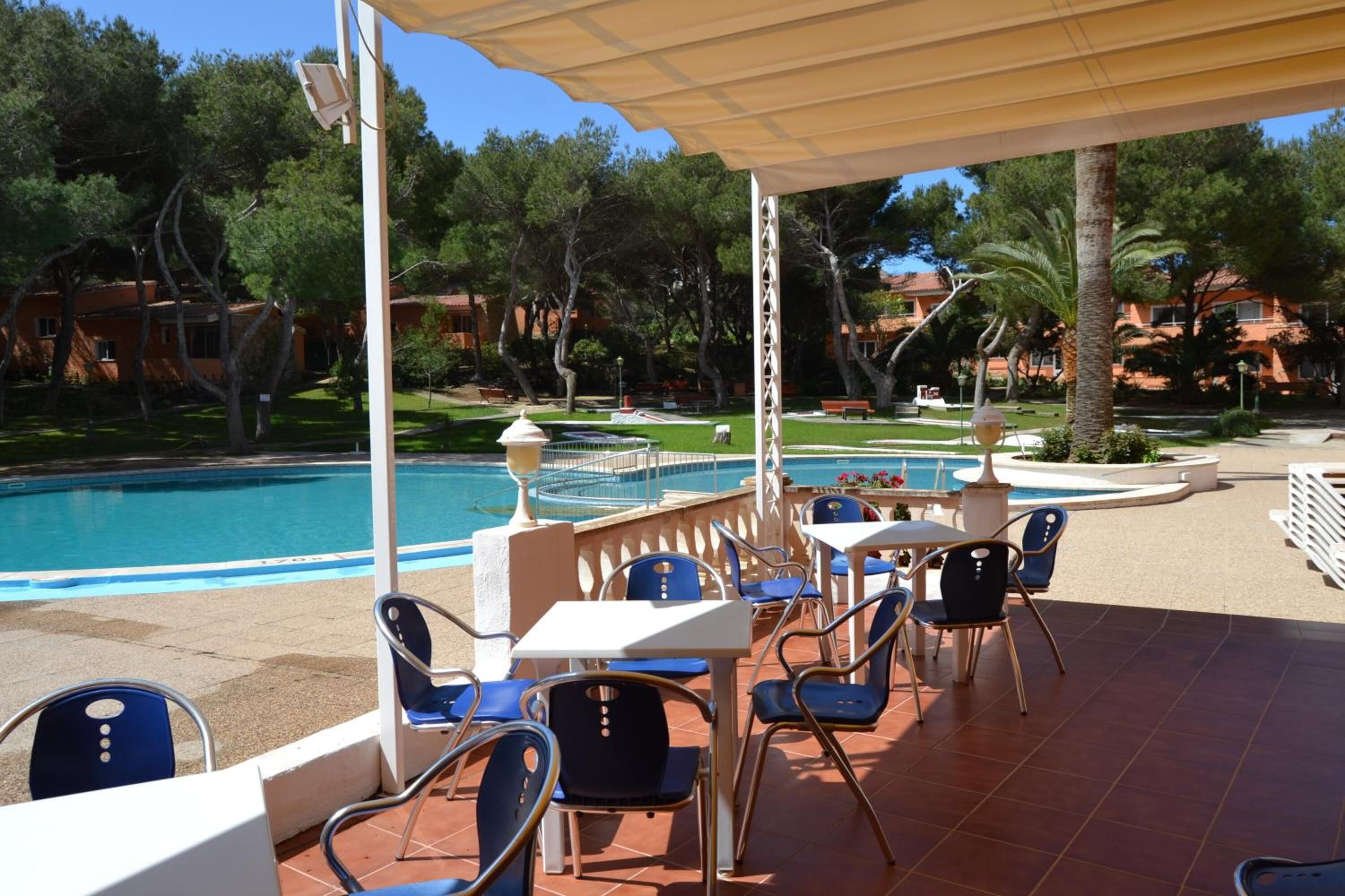 A poolside area with outdoor seating and a pool.