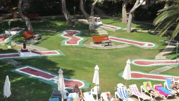 Zona de piscina con tumbonas y diseño geométrico de la piscina.