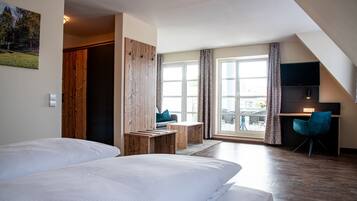 A modern hotel room with two beds, a desk, a chair, and a large window with curtains.