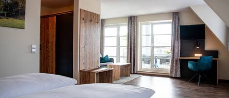 Une chambre d’hôtel moderne équipée de deux lits, d’un bureau, d’une chaise et d’une grande fenêtre avec des rideaux.