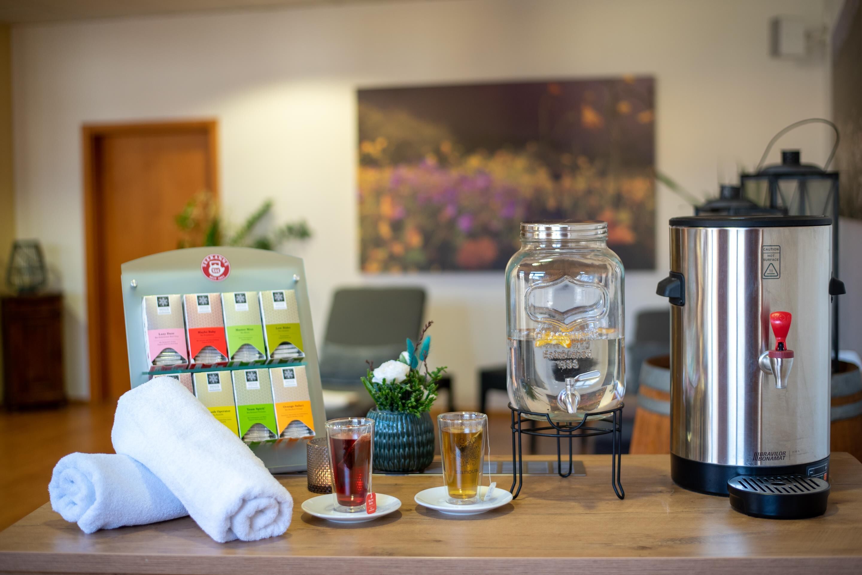 A bar area with a coffee machine, a glass jar, and a selection of bottled beverages.