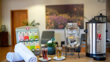 A bar area with a coffee machine, a glass jar, and a selection of bottled beverages.