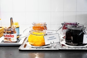 A variety of food items, including jars labeled with names like 'Nutella' and 'Orange Marmalade', arranged on a tray. - Hotell Silverhatten (Arjeplog)