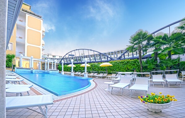 Piscine couverte, piscine extérieure, parasols de plage, chaises longues