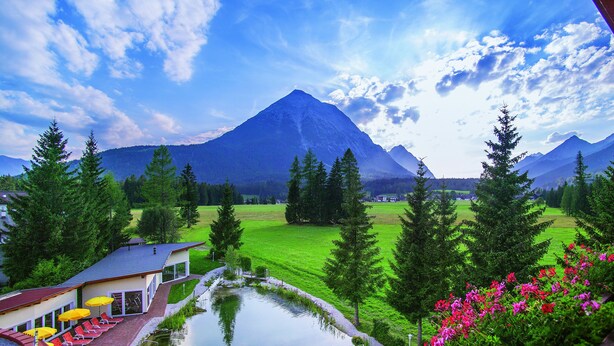 Un hôtel doté d’une piscine, d’un espace extérieur aménagé et offrant une vue sur la montagne.