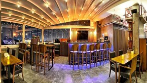 A bar area with a curved ceiling, bar stools, and a view of the city through large windows. - Samir Deluxe Hotel (Istanbul)