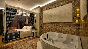 A bedroom with a four-poster bed, a large bathtub, and a stone wall. - Samir Deluxe Hotel (Istanbul)
