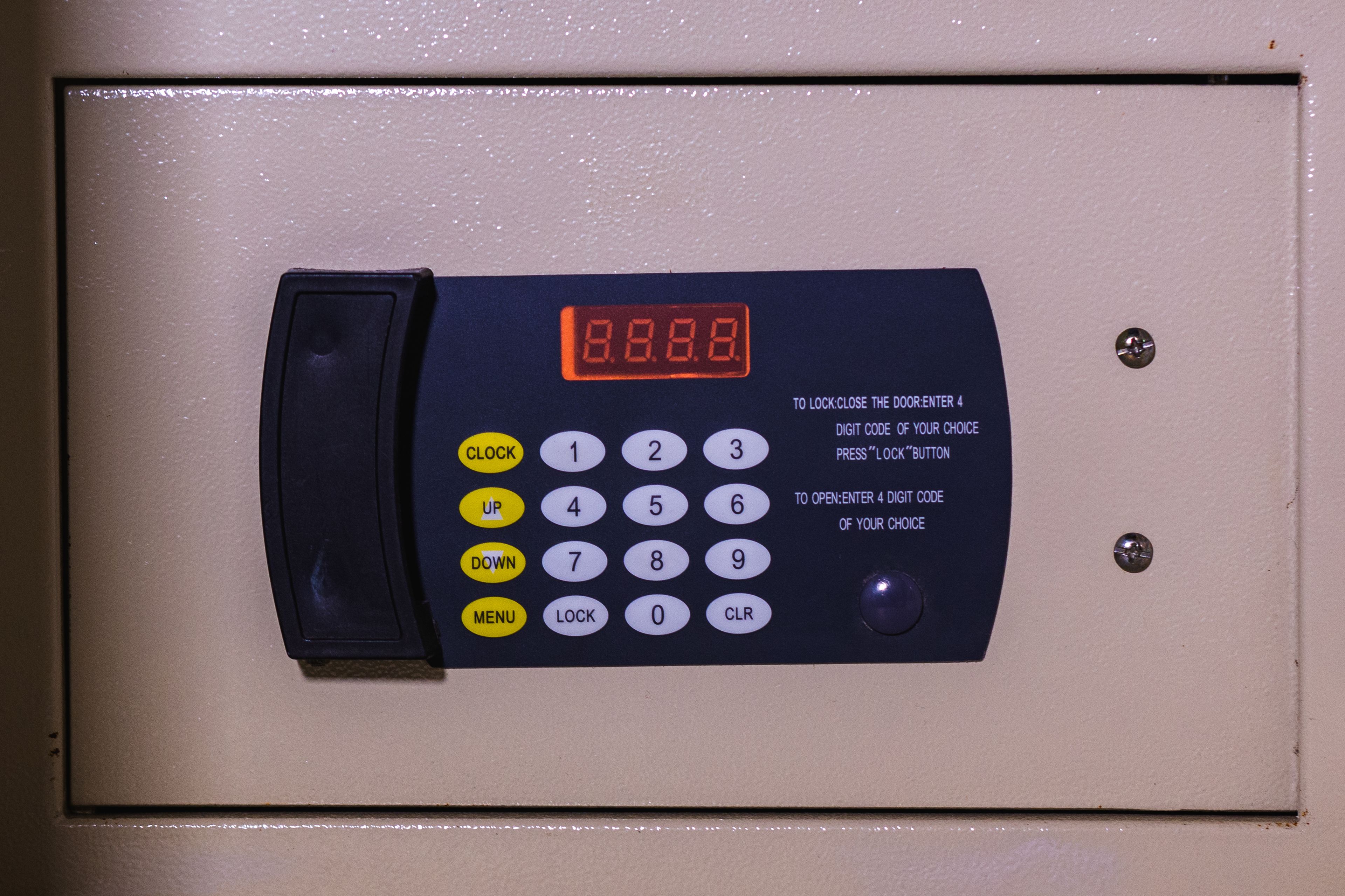 A digital hotel room phone with a keypad and instructions for locking and unlocking the door.