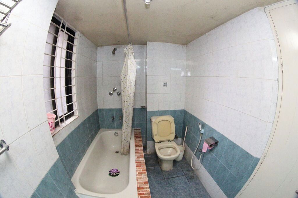 Un baño con bañera, inodoro y cortina de ducha.