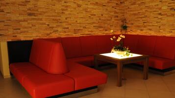 Un interior moderno con un sofá rojo y una mesa de madera con un jarrón de flores.