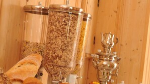 A buffet table with various breads, a wicker basket, and a large chocolate cake. - Beierleins Hotel & Catering GmbH (Callenberg)