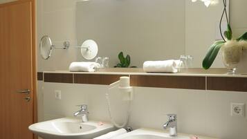 A bathroom with two sinks, a mirror, and a towel rack.