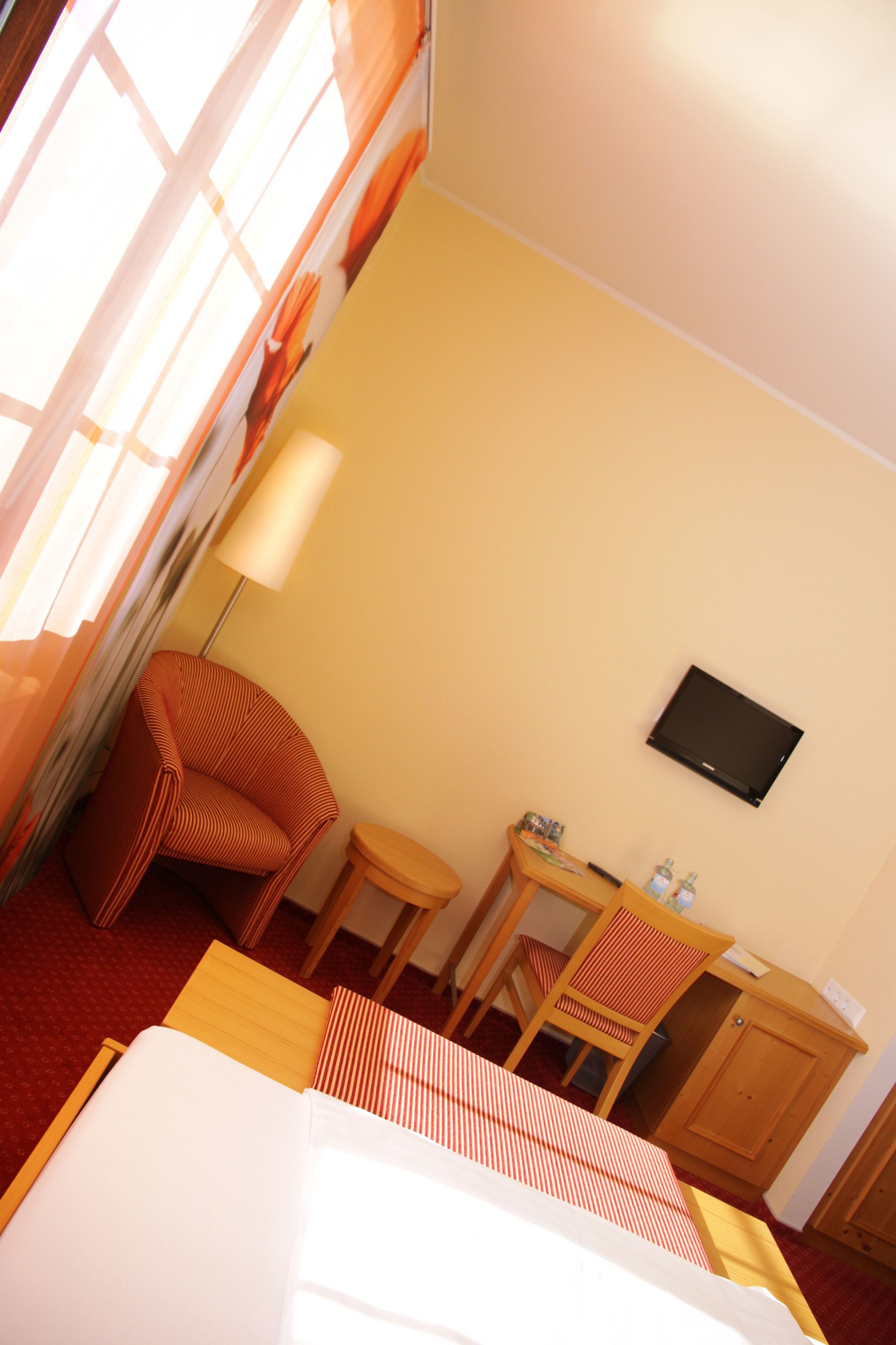 Una habitación de hotel con una cama, un escritorio, una silla, un televisor y un armario.