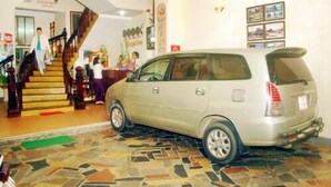 A car parked inside a building with a staircase leading to a reception area. - Nhu Phu Hotel (Hue)