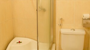 A bathroom with a glass-enclosed shower, a toilet, and a sink. - Nhu Phu Hotel (Hue)