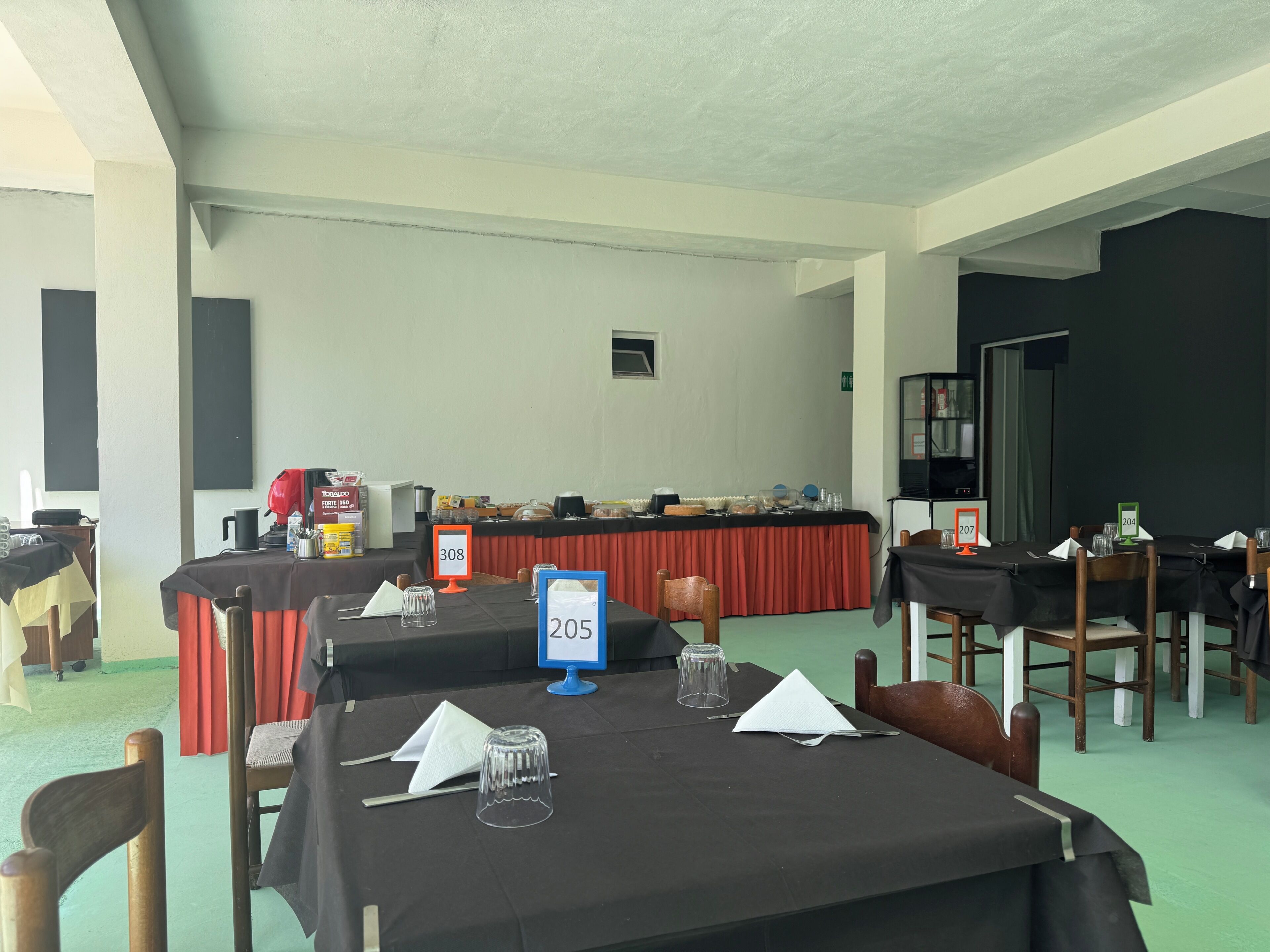 A conference room with tables, chairs, and a buffet table.